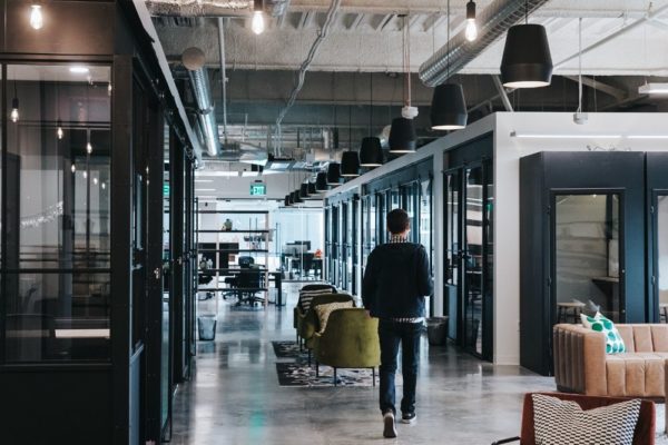 Person walking through hallway with multiple meeting rooms in Utah office